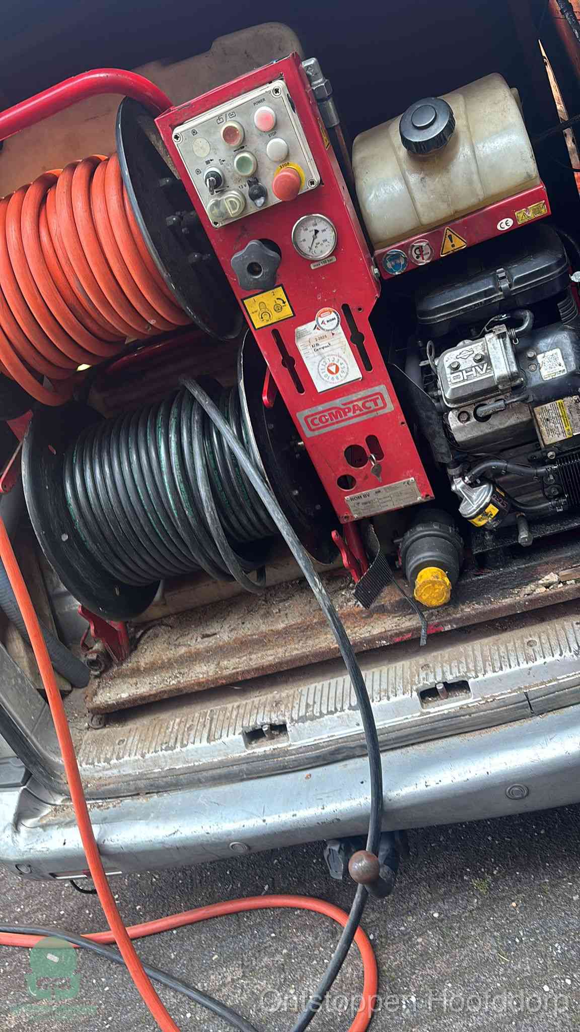 Een rood hogedruk-rioolreinigingstoestel in de laadbak van de bedrijfsbus, apparatuur voor een hardnekkige afvoerverstopping in Hoofddorp
