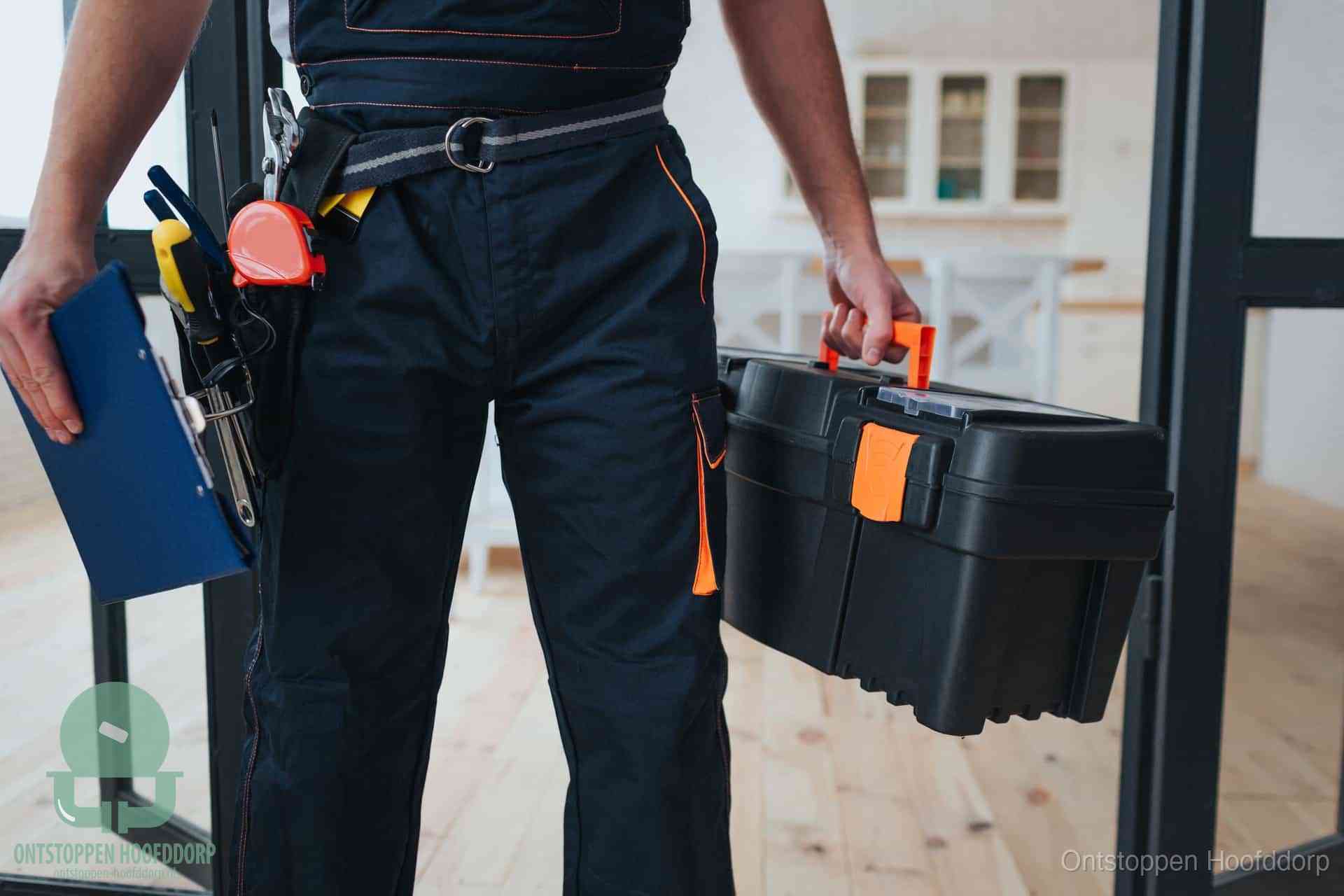 Een monteur met gereedschapsriem en klembord, klaar om een transparante prijs voor het afvoer ontstoppen in Hoofddorp te geven