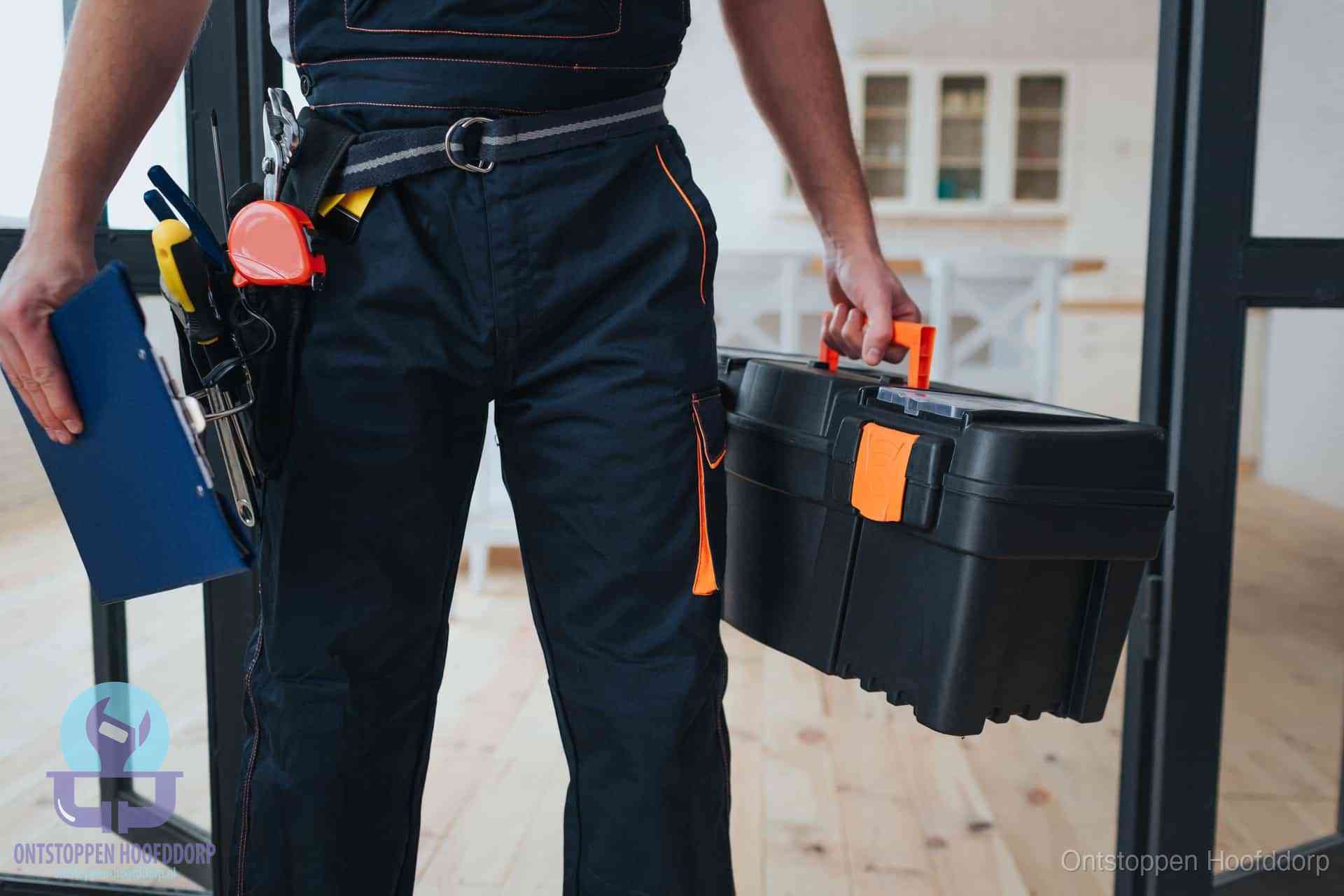 Een monteur met gereedschapsriem en klembord in een keuken, klaar om een transparante prijs voor het gootsteen ontstoppen in Hoofddorp te geven
