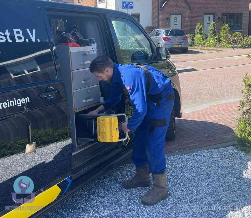 Een monteur pakt apparatuur uit de bedrijfsbus voor service aan huis, het moment om een professional in te schakelen voor een verstopte wc in Hoofddorp