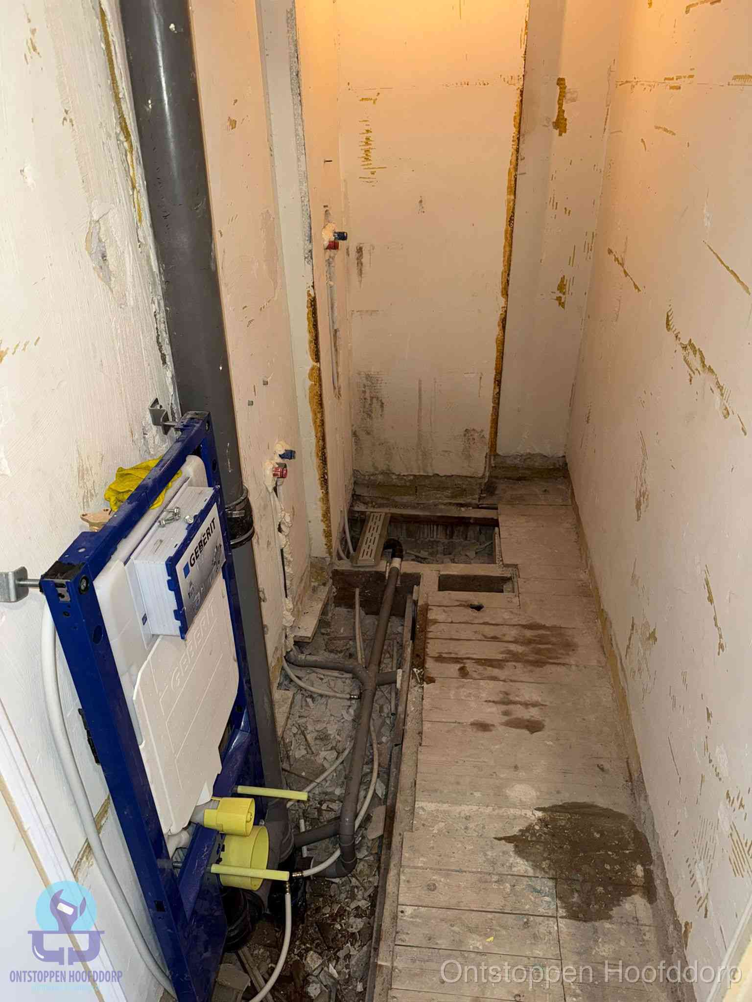 Een opgebroken toiletruimte tijdens renovatie met een Geberit inbouwreservoir en blootliggende oude afvoerleidingen, typisch voor oudere woningen in Hoofddorp